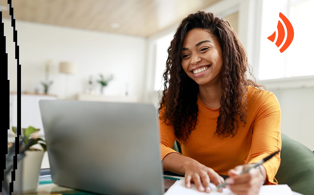 Mulher sorridente, de cabelos cacheados, usando uma blusa laranja enquanto usa um nootbook. Ela faz anotações em um caderno. Há um ícone de wi-fi no canto, parte da identidade visual da Brisanet.